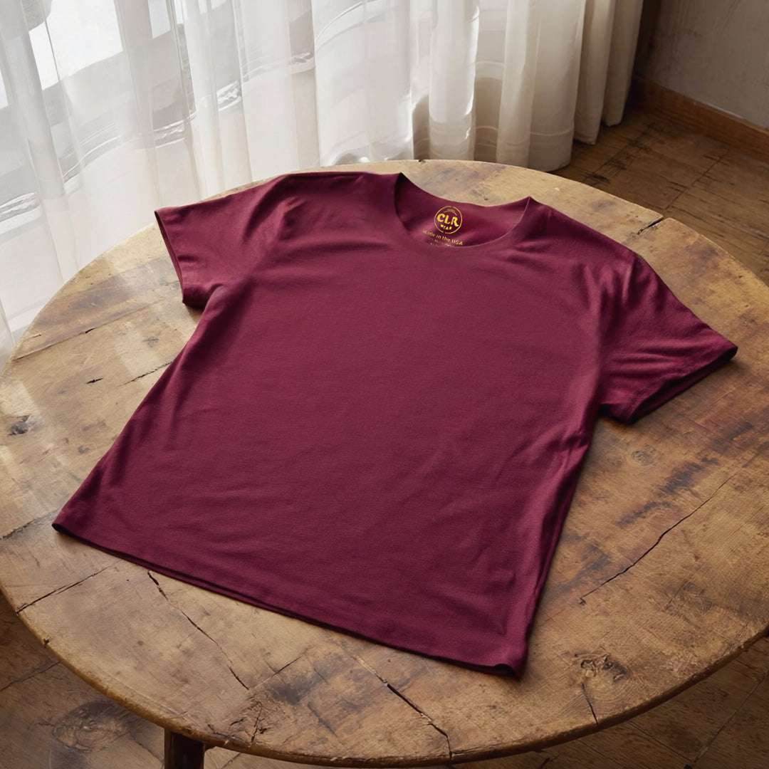 Maroon Basic Tee on a wooden table, showcasing raw edges and custom fit.