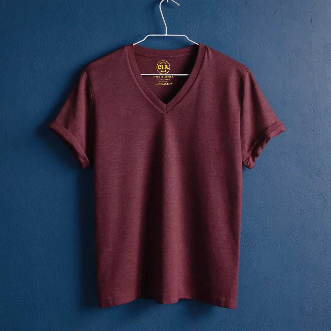 The Business Tee in maroon with V-neck and tailored fit, hanging on a hanger against a blue background.