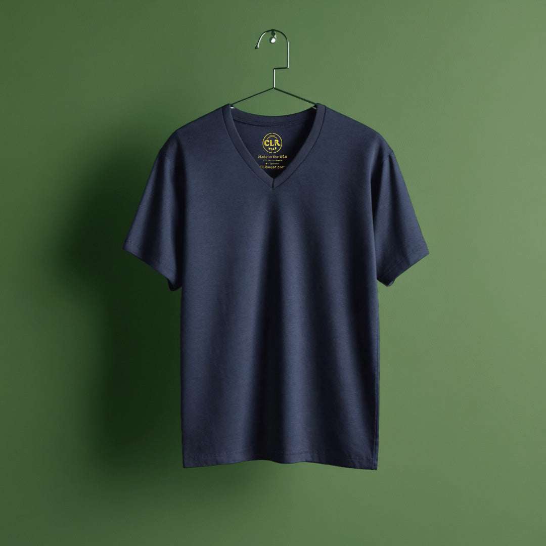 Navy "The Business Tee" with v-neck, crafted from ultra-soft micro-modal fabric, displayed on a hanger against a green background.